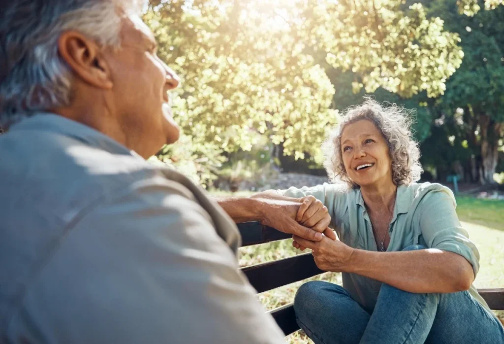 Senior couple sitting together on a bench in a garden